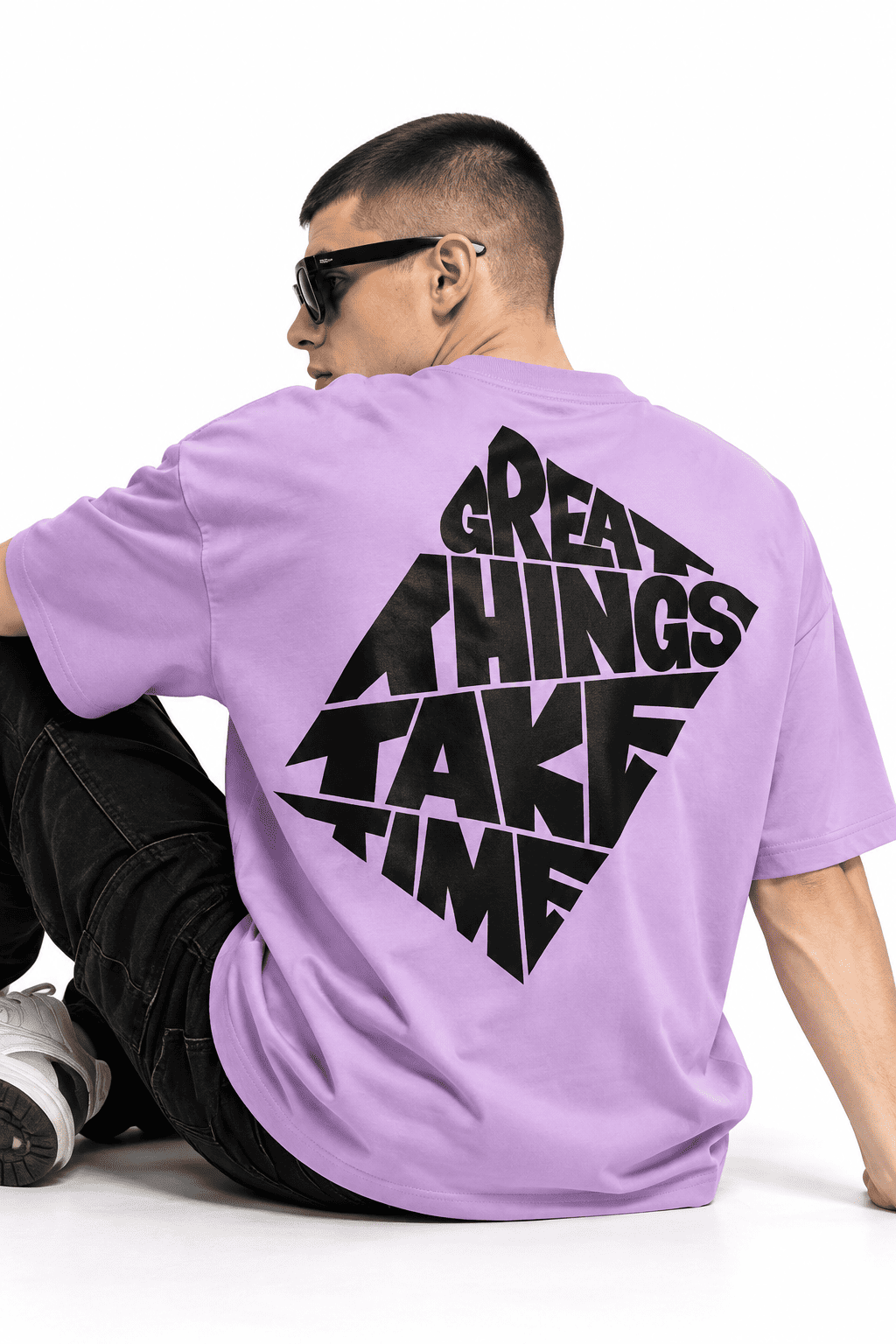 Great Things Take Time Oversized Tee 5 Seated model wearing lavender Great Things Take Time Oversized Tee showing the black back graphic