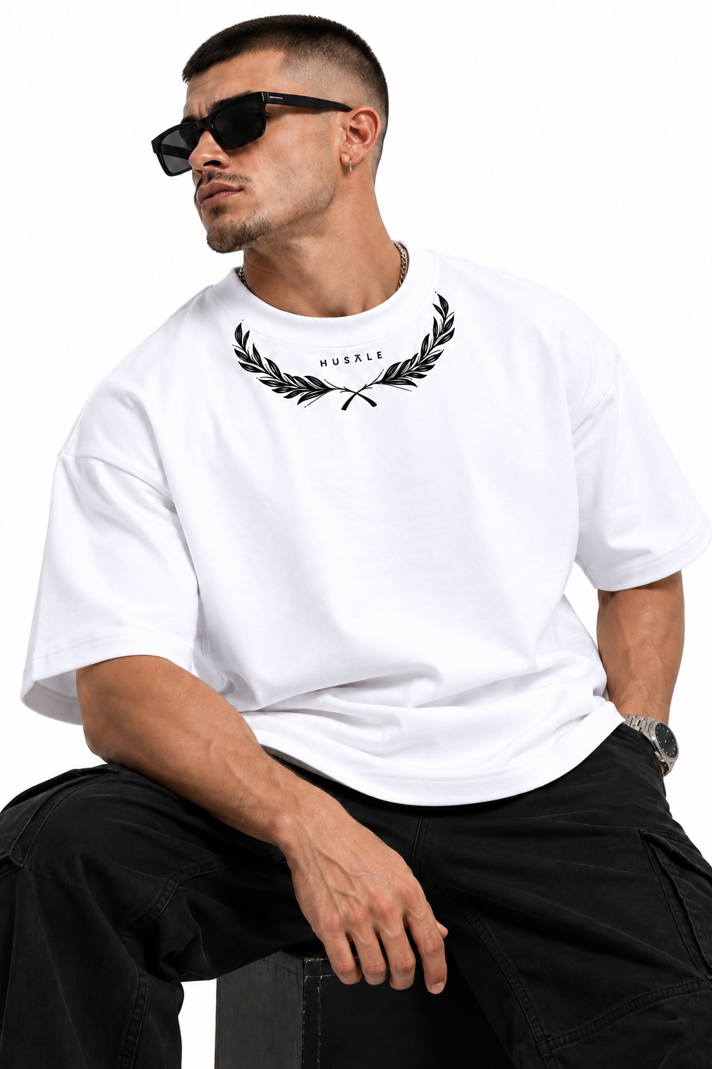 Hustle Laurel Oversized Tee 3 Seated model wearing White Hustle Laurel Oversized Tee with black laurel neckline artwork